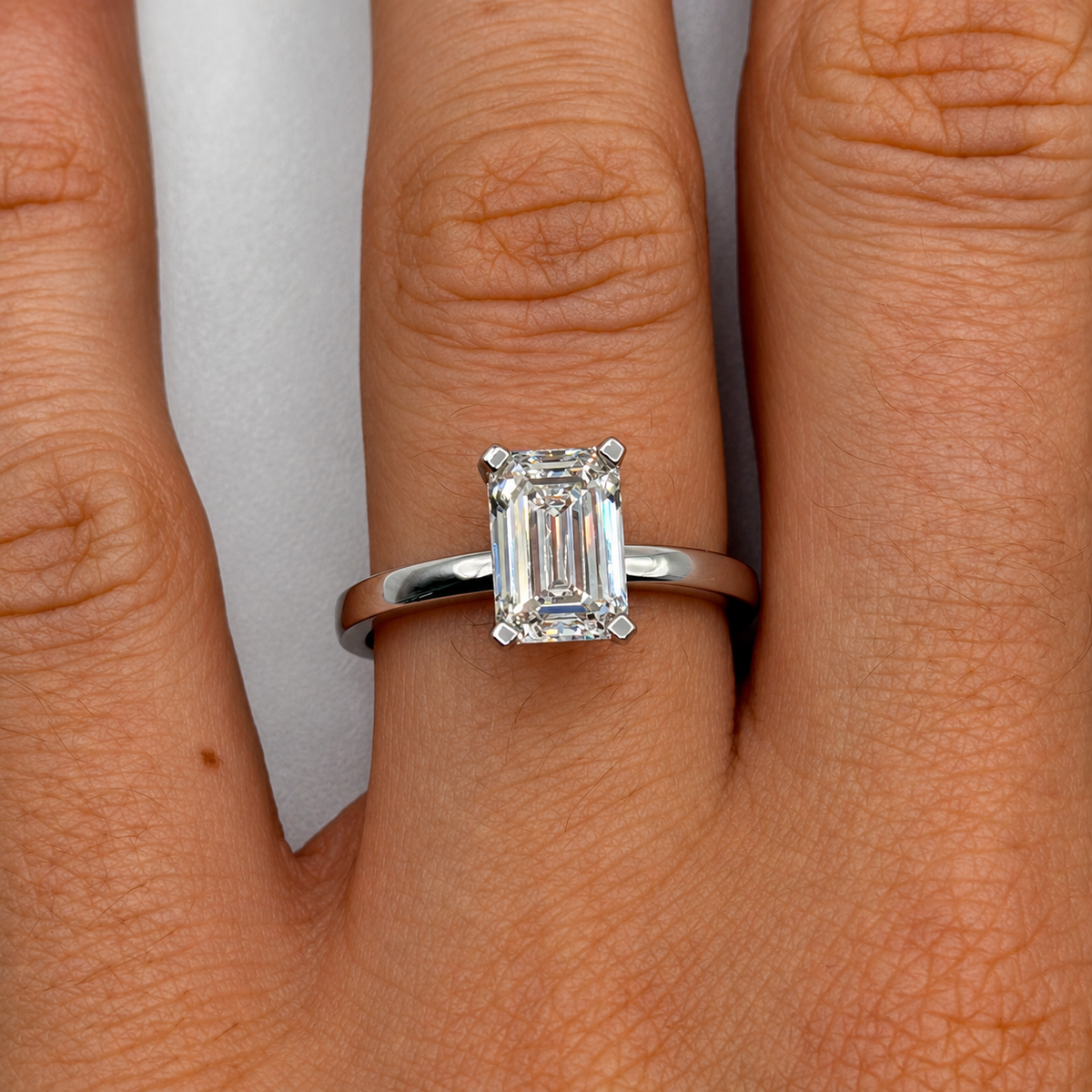 2.02 carat emerald-cut solitaire diamond ring in white gold worn on hand